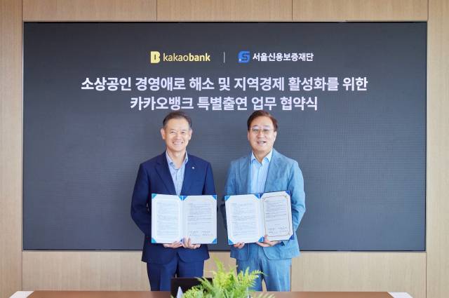 윤호영(오른쪽) 카카오뱅크 대표이사와 최항도 서울신용보증재단 이사장이 25일 경기도 성남시 카카오뱅크 판교오피스에서 진행된 '카카오뱅크 특별출연 업무 협약식'에 참석해 기념 촬영을 하고 있다. 카카오뱅크 제공