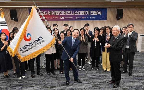 유정복 인천시장이 '2026 세계한인비즈니스대회기 전달식'에서 이상덕 재외동포청장에게 받은 대회기를 들어보이고 있다.