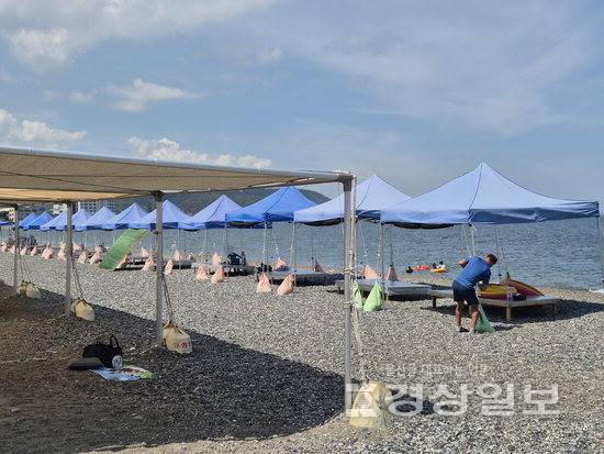 ▲ 울산 북구 강동 몽돌해변에서 매년 반복돼온 불법 평상 대여 영업이 올해도 적발돼 검찰에 넘겨질 예정이다. 앞쪽 파란색 평상은 업자들이, 뒤쪽그늘막은 북구가 설치했다.