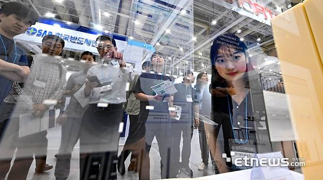 경기도와 수원시가 주최하고 전자신문 등이 주관하는 차세대 반도체 패키징 산업전이 27일 경기 수원시 수원컨벤션센터에서 열렸다. 참관객이 켐트로닉스의 유리기판을 살펴보고 있다.  수원=이동근기자 foto@etnews.com