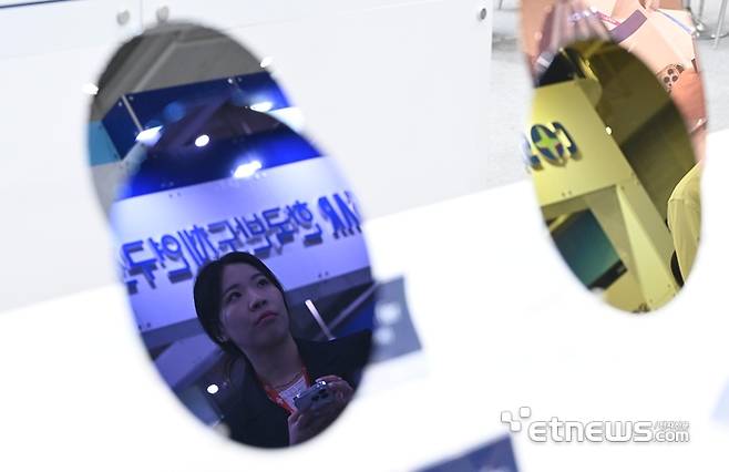 경기도와 수원시가 주최하고 전자신문 등이 주관하는 차세대 반도체 패키징 산업전이 27일 경기 수원시 수원컨벤션센터에서 열렸다. 참관객이 제이쓰리의 실리콘 웨이퍼를 살펴보고 있다.  수원=이동근기자 foto@etnews.com