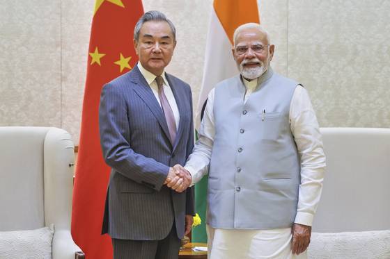 지난 19일(현지시간) 인도 뉴델리를 방문한 왕이 중국 외교부장(왼쪽)이 나렌드라 모디 인도 총리를 만나 악수하고 있다. [AP=뉴시스]