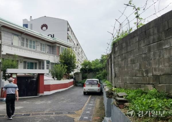 26일 오전 인천 부평구 부개동 군 관사 삼마아파트 재건축 부지(오른쪽) 인근에 있는 2층짜리 주택과 9차동원아파트 방향으로 한 주민이 걸어가고 있다. 황남건기자
