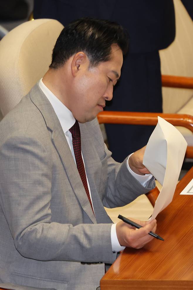 장동혁 국민의힘 대표가 27일 국회 본회의장에서 서류 봉투를 열어보고 있다. [사진 출처 = 연합뉴스]