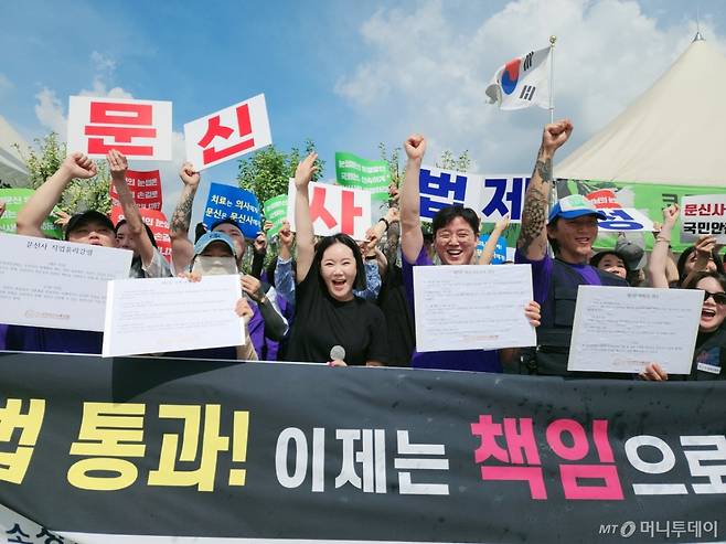 27일 오전 11시19분 '문신사법'이 국회 보건복지위원회 전체회의를 통과한 직후, 대한문신사중앙회 임보란(가운데) 회장과 회원들이 환호하고 있다. /사진=정심교 기자