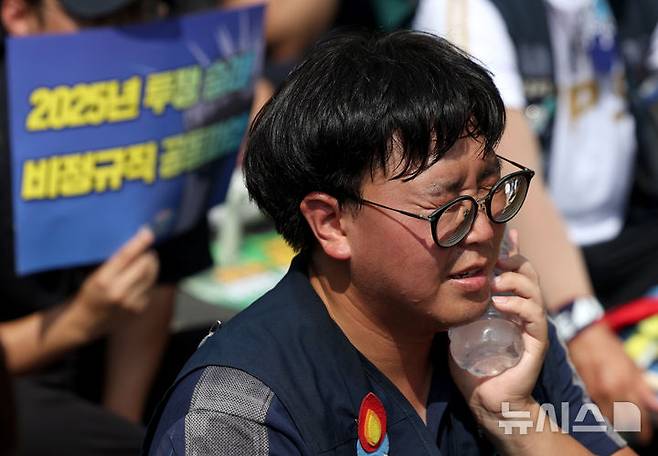[서울=뉴시스] 김진아 기자 = 27일 서울 용산구 삼각지역 부근에서 열린 '2025년 임단협 승리!, 죽지 않고 일할 권리 쟁취!, 발전소 노동자 총고용 보장' 발전 비정규직노동자 총파업대회에서 한 참석자가 얼음물로 더위를 식히고 있다. 2025.08.27. bluesoda@newsis.com