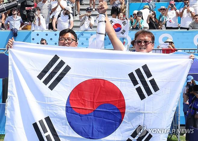 파리 올림픽 양궁 전 종목 석권의 순간, 김우진과 함께 태극기 든 박성수 감독(오른쪽) [파리=연합뉴스]