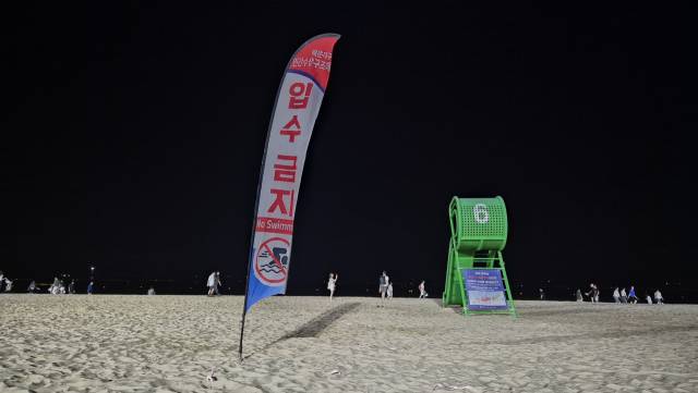 지난 25일 오후 9시께 부산 해운대해수욕장 모습. 해운대구 민간수상구조대는 오후 6시 퇴근에 맞춰 망루 뒷편에 입수 금지 배너를 설치한다. 해수욕장 개장 기간 입수 허용 시간은 매일 오전 9시부터 오후 6시까지로 제한돼 있다. 박수빈 기자