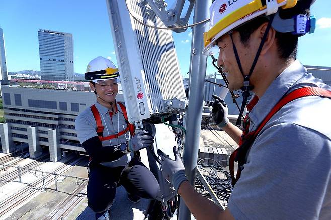LG유플러스 직원들이 용산역 인근 건물 옥상에 설치된 5G 장비를 점검하고 있는 모습./LG유플러스