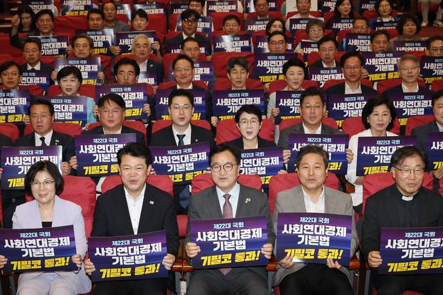 28일 서울 여의도 국회 의원회관에서 열린 더불어민주당 사회연대경제 입법 한마당 및 더불어민주당 입법추진단 발족식에서 우원식 국회의장 등 참석자들이 손팻말을 들고 있다. [연합뉴스]
