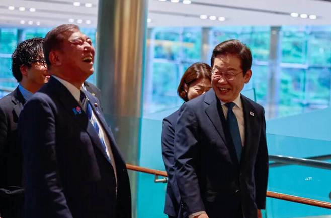 이재명 대통령이 지난 23일 일본 도쿄 총리 관저에 도착해 이시바 시게루 일본 총리와 대화하며 이동하고 있다. 연합뉴스
