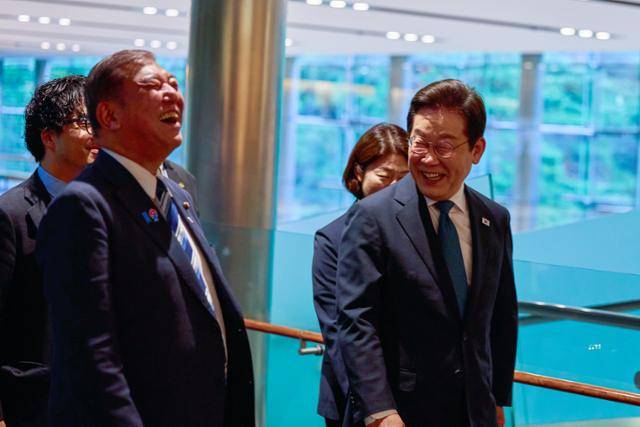 이재명 대통령이 23일 일본 도쿄 총리 관저에 도착해 이시바 시게루 총리와 환하게 웃으며 이동하고 있다. 도쿄=연합뉴스