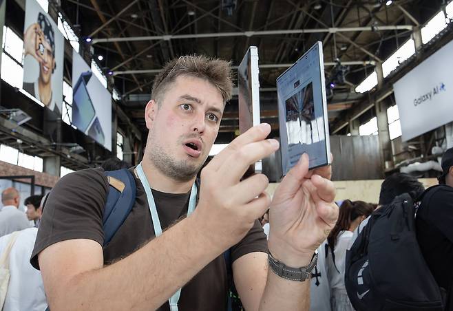 갤럭시 제품 공개 행사에 참가한 관람객이 ‘갤럭시Z 플립7’의 두께를 보며 놀라워하고 있다./삼성전자 제공