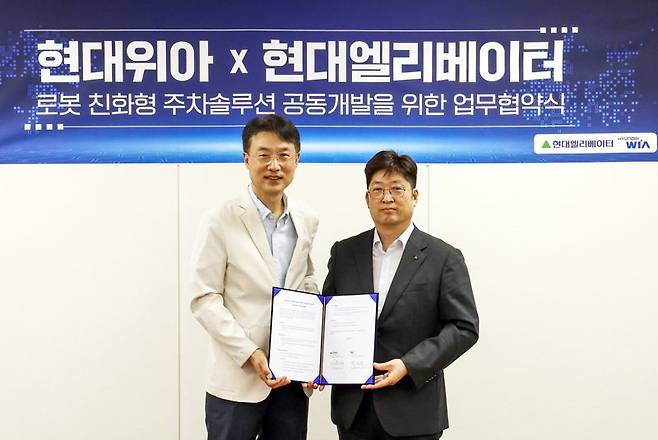 이원해 현대엘리베이터 승강기사업본부장(오른쪽)과 백익진 현대위아 모빌리티솔루션사업부장이 28일 오후 경기도 현대위아 의왕연구소에서 업무협약(MOU)을 체결한 뒤 포즈를 취하고 있다. 현대엘리베이터 제공
