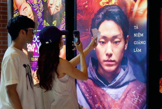 지난해 4월 베트남 청년들이 하노이 CGV에 걸린 '파묘' 포스터 앞에서 기념 촬영을 하고 있다. 파묘의 베트남 제목은 'EXHUMA: QUẬT MỘ TRÙNG MA'다. 직역하면 파묘: 유령무덤 발굴. 하노이=허경주 특파원