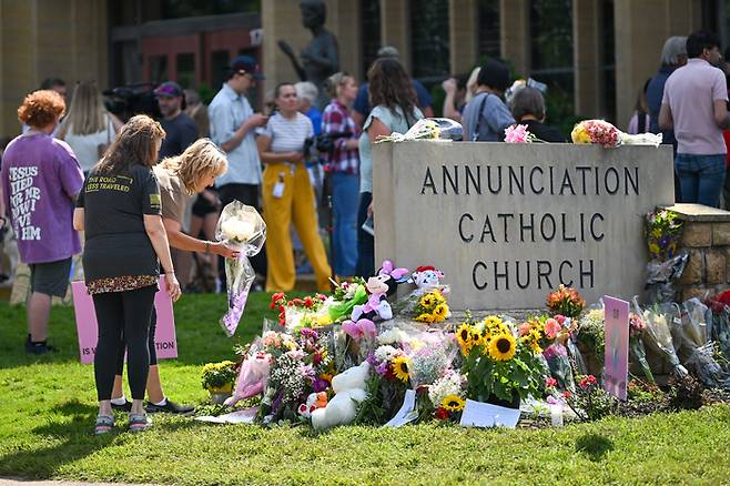 총기 난사 사건이 벌어진 미국 미네소타주 미니애폴리스 소재 가톨릭 학교(Annunciation Catholic School)에 28일(현지시간) 주민들이 모여있는 모습. [사진 출처 = UPI, 연합뉴스]