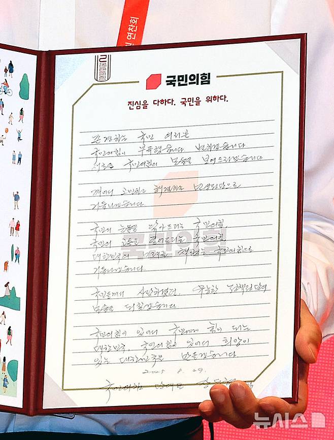 [인천=뉴시스] 김금보 기자 = 장동혁 국민의힘 대표가 29일 오전 인천 중구 인천국제공항공사 항공교육원에서 열린 2025 국민의힘 국회의원 연찬회에서 직접 작성한 국민께 드리는 손편지를 펼쳐 보이고 있다. 2025.08.29. kgb@newsis.com
