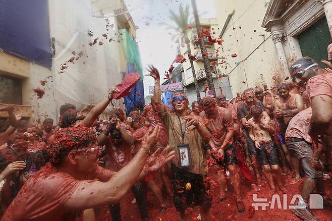 [부뇰=AP/뉴시스] 지난 27일(현지 시간) 스페인 발렌시아 인근 부뇰 마을에서 열린 연례 '라 토마티나' 축제 참가자들이 토마토 범벅이 된 채 축제를 즐기고 있다. 이 축제는 매년 8월 마지막 수요일에 열리며 1945년경, 마을 축제 도중 우연히 시작된 토마토 던지기에서 유래한 것으로 알려져 있다. 2025.08.29.