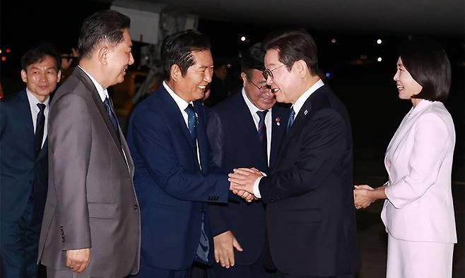 이재명 대통령과 김혜경 여사가 일본·미국 방문 일정을 마치고 지난 28일 경기도 성남 서울공항에 도착해 영접 나온 더불어민주당 정청래 대표와 인사하고 있다. 연합뉴스