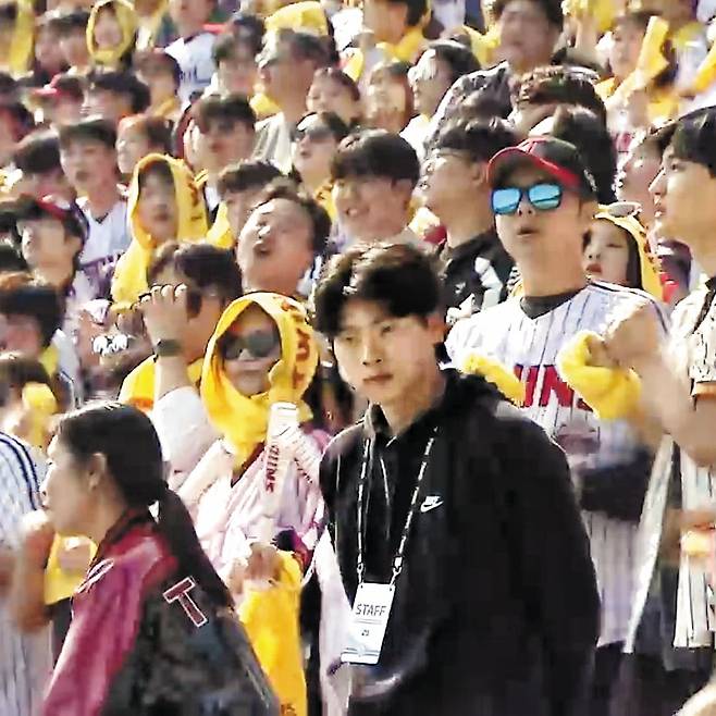 지난 3월 박찬형(검은 옷)이 보안 요원으로 야구장에서 일하는 모습이 중계 화면에 포착됐다. / KBS