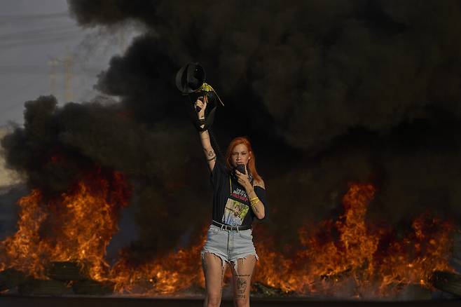 가자지구 전쟁 종식과 인질 석방을 촉구하는 대규모 반전 시위가 26일(현지시각) 이스라엘에서 열렸다.100만 명의 시민이 거리로 나와 정부에 휴전안 수용을 요구했지만, 베냐민 네타냐후 이스라엘 총리는 이를 거부하며 군사 작전 확대 방침을 확고히 했다. 한 활동가가 고속 도로 위에서 시위를 벌이고 있다. 텔아비브/AP 연합뉴스