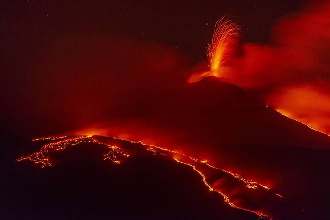 이탈리아 시칠리아섬에 있는 유럽 최대 활화산 에트나산의 남동쪽 분화구에서 26일(현지시각) 용암이 흘러내리고 있다. 시칠리아/AP 연합뉴스