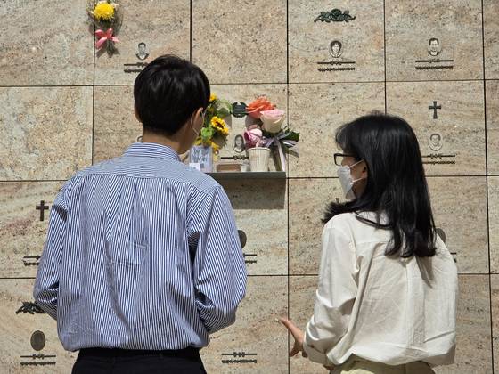 서현역 난동 살인범 최원종(24)에게 희생된 고 김혜빈(사망 당시 20세)씨의 아버지(왼쪽)와 어머니(오른쪽)가 지난해 4월 경기 성남시 야탑동 분당메모리얼파크 봉안당에서 딸의 영정 앞에 생전 즐겼던 커피와 쿠키를 놓아주고 있다. 손성배 기자