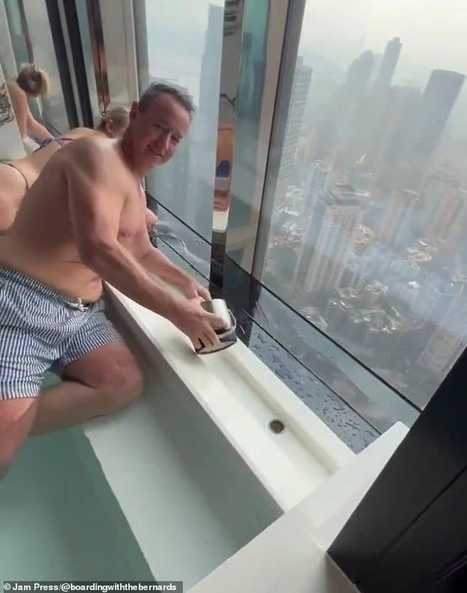 호주인 부부가 양동이로 물을 퍼내는 것을 돕고 있다./사진=데일리메일 캡처