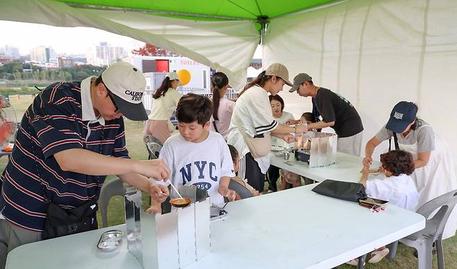 가족단위의 관람객들이 영화 관람에 앞서 달고나 체험을 하고 있다. 이수화 기자