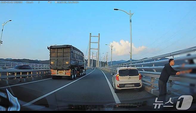 마산소방서 이보검 소방사가 지난 29일 오후 마창대교에서 극단적 선택을 하려던 여성을 붙잡고 설득하고 있다.(마산소방서 제공. 재판매 및 DB금지)