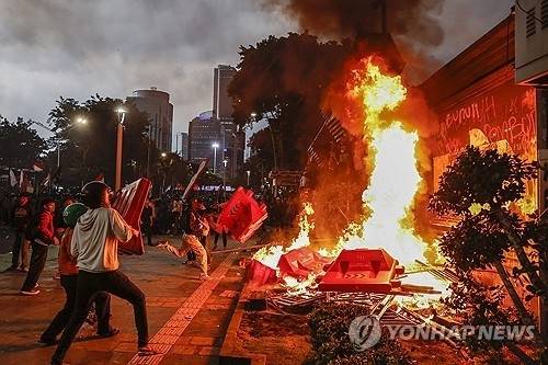 29일(현지시간) 인도네시아 수도 자카르타에서 시위대들이 국회의원 특혜와 시위 참가자 사망을 규탄하며 경찰청 정문 및 인근 건물에 불을 지르고 있다. [EPA 연합뉴스]