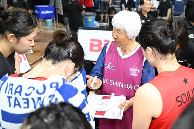 박신자 여사(오른쪽 2번째)가 작전판을 들고 BNK 선수들에게 조언하고 있다. /사진=WKBL 제공