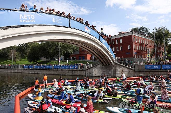 지난 9일(현지시간) 러시아 야우자강에서 열린 '2025 야우자 축제'에 참석한 패들보더들  [타스 연합뉴스 자료사진. 재배포 및 DB 금지]