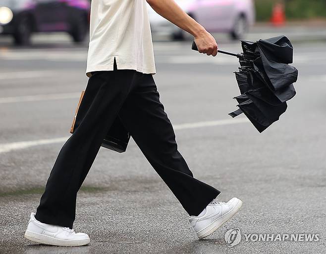 우산이 필요한 날 (서울=연합뉴스) 김도훈 기자 = 비가 소강상태에 접어든 26일 오전 서울 광화문사거리에서 한 시민이 우산을 접어 들고 횡단보도를 건너고 있다.
기상청은 26일 전국이 대체로 흐리고 오후까지 대부분 지역에 비가 내릴 것으로 예보했다. 2025.8.26 superdoo82@yna.co.kr