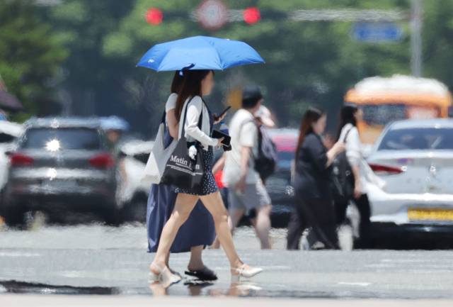 지난달 2일 부산 해운대구 벡스코 인근 도로에서 시민들이 지열로 아지랑이가 피어오르는 횡단보도를 건너고 있다. 정종회 기자 jjh@