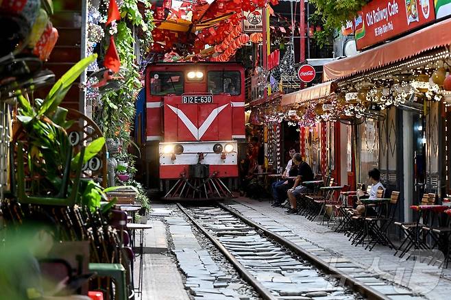 지난달 18일 베트남 하노이 '기찻길 카페거리'를 지나는 철도 선로에 열차가 진입하고 있다. 2025.8.31. ⓒ AFP=뉴스1 ⓒ News1 심서현 기자 ⓒ AFP=뉴스1 ⓒ News1 심서현 기자