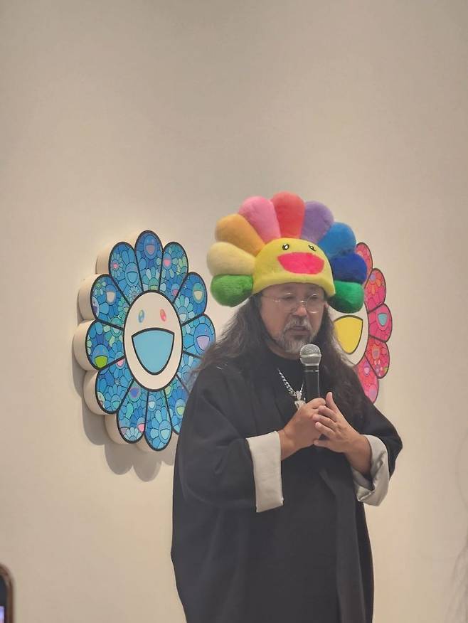 1일 서울 용산 아모레퍼시픽 본사 1층의 프로젝트 공간 APMA에서 열린 다카시 무라카미 작가의 개인전 '서울, 귀여운 여름방학'에서 작가가 활짝 웃는 꽃 이미지 모자를 쓰고 발언하고 있다. 서믿음 기자