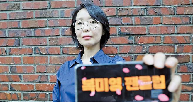 본지와 만난 소설가 박지영이 스마트폰으로 “복미영 팬클럽” 전광판 문구를 만들어 보였다. 그는 “적극적으로 팬클럽 홍보에 임하고 있다”며 웃었다./남강호 기자