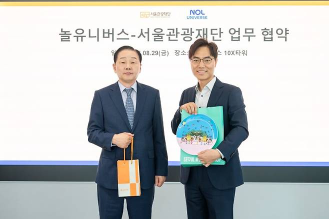길기연 서울관광재단 대표이사(왼쪽)와 배보찬 놀유니버스 대표가 업무협약을 체결한 뒤 기념품을 교환하고 있다. 서울관광재단 제공