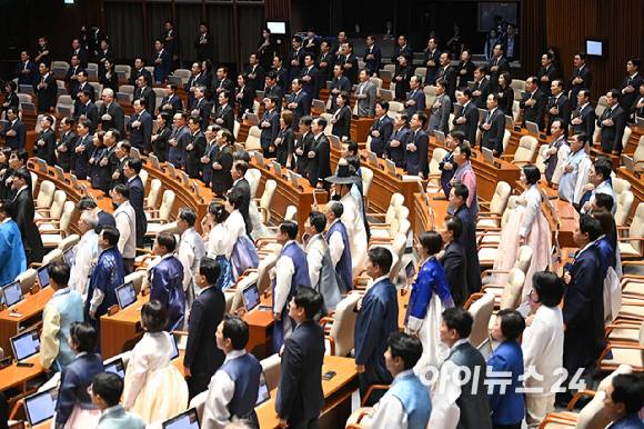 1일 오후 서울 여의도 국회에서 열린 제429회 국회(정기회) 개회식에서 의원들이 국민의례를 하고 있다. 국민의힘 의원들의 검은 옷과 더불어민주당 의원 등의 한복이 대비되고 있다. [사진=곽영래 기자]