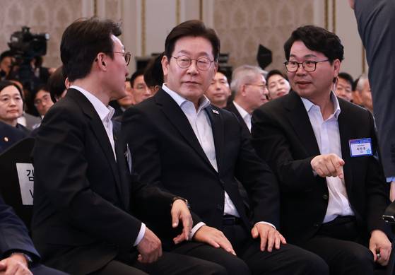 이재명 대통령이 13일 청와대 영빈관에서 열린 국정기획위원회 국민보고대회에서 김민석 국무총리와 대화하고 있다. 오른쪽은 이한주 국정기획위원장. 연합뉴스