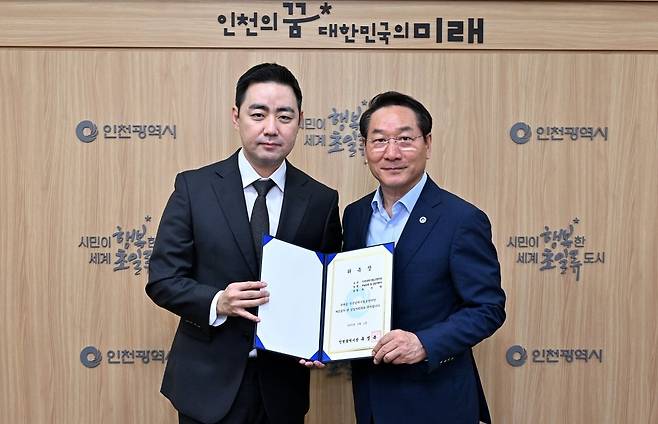인천시립교향악단의 새 예술감독이 된 지휘자 최수열(왼쪽)이 위촉장을 들고 유정복 인천시장과 기념 사진을 찍고 있다. / 사진출처. 인천문화예술회관.