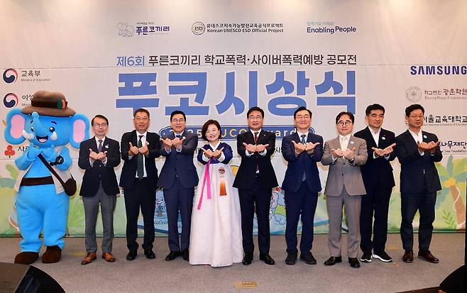 삼성전기가 주최한 제6회 푸른코끼리 학교폭력·사이버폭력 예방 공모전 시상식에서 주요 참석자들이 사이버폭력 예방에 동참하겠다고 약속하는 손 모양을 취하고 있다. 왼쪽부터 박길성 푸른나무재단 이사장, 윤도영 광운대 총장, 김영곤 교육부 차관보, 진선미 더불어민주당 의원, 김대식 국민의힘 의원, 장신호 서울교대 총장, 장덕현 삼성전기 사장.  삼성전기
