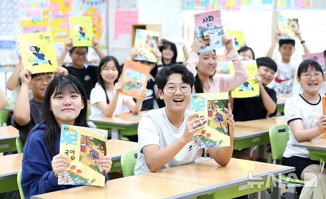 [대구=뉴시스] 이무열 기자 = 여름방학을 마치고 개학한 1일 대구 수성구 대구성동초등학교 6학년 11반 학생들이 새로 받은 2학기 교과서를 들어 보이고 있다. 2025.09.01. lmy@newsis.com