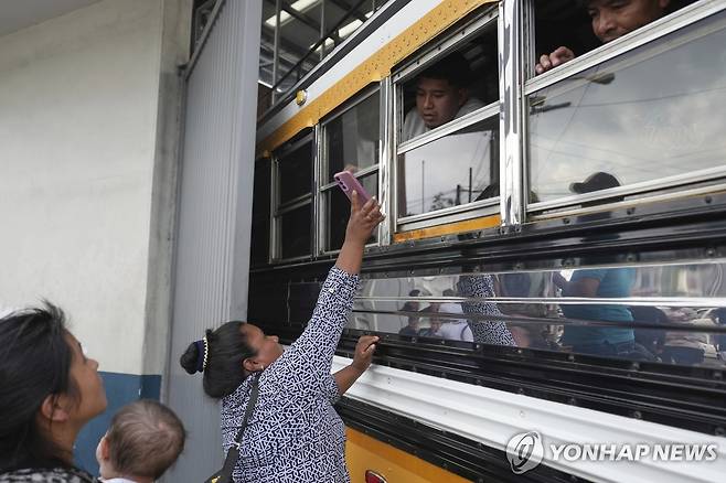 Guatemala US Deportation Flights 31일(현지시간) 과테말라 과테말라시티의 라오로라 국제공항 앞에서 한 여성이 미국에서 추방된 이민자에게 자신의 친척을 아는지 물어보며 휴대전화를 보여주고 있다. [AP=연합뉴스]