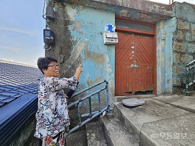 1일 오후 목포시 유달동 시화마을에서 만난 박동금(76·여) 씨가 손으로 빈 집을 가리키고 있다. 해당 집을 비롯해 옆집, 맞은편 집 등 마을 내 다수의 주택들이 비어 있었다.