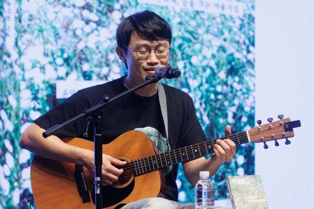 밴드 '브로콜리너마저'의 윤덕원이 2일 서울 종로구 노무현시민센터에서 열린 '열심히 대충 쓰는 사람' 출간 기자간담회에서 책 제목과 동명의 신곡을 부르고 있다. 연합뉴스