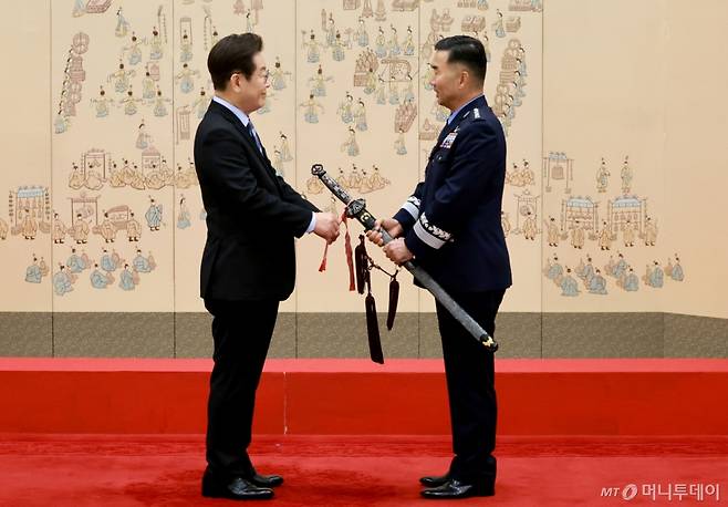 [서울=뉴시스] 최동준 기자 = 이재명 대통령이 2일 서울 용산 대통령실 청사에서 열린 대장 진급·보직 신고 및 삼정검 수치 수여식에서 합동참모의장 후보자인 진영승 전략사령관의 삼정검에 수치를 달아주고 있다. (대통령실통신사진기자단) 2025.09.02. photocdj@newsis.com /사진=