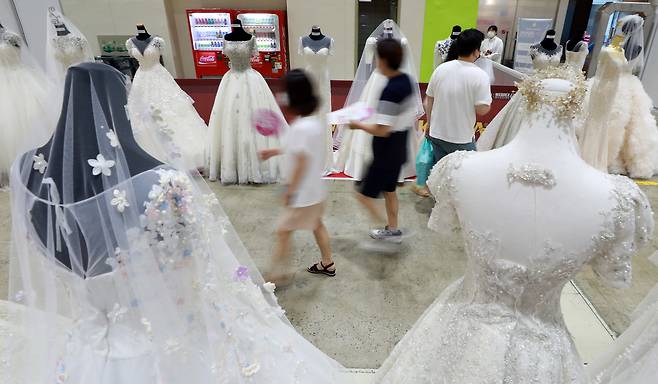 웨딩박람회를 찾은 예비 부부들이 웨딩드레스를 살펴보고 있다. 사진은 기사 내용과는 관련 없음 [뉴시스]