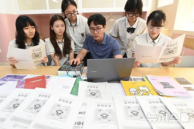 [수원=뉴시스] 김종택 기자 = 2026학년도 대학수학능력시험 응시원서 접수가 시작된 8월 21일 경기 수원시 영복여자고등학교에서 고3 수험생들이 선생님과 함께 수능 실시요강 등을 살펴보고 있다. 2025.08.21. jtk@newsis.com **기사 내용과 직접 관련 없습니다**